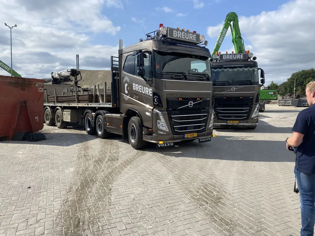 Twee Volvo-vrachtwagens met draadloze besturing op een bedrijfsterrein